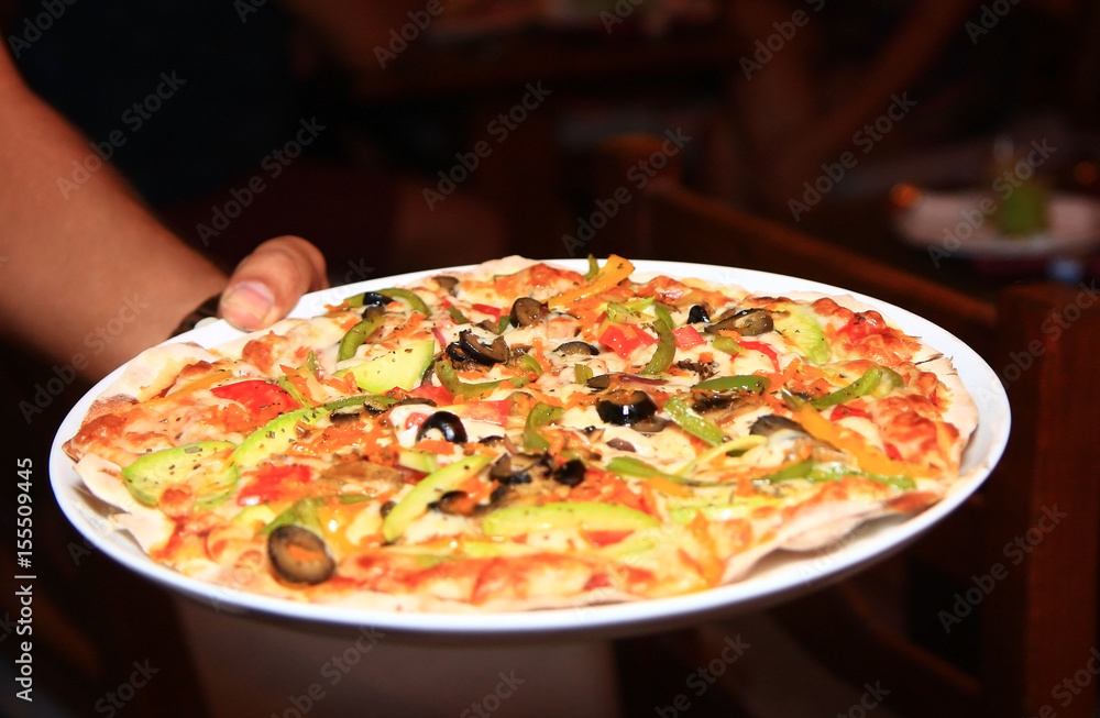 Pizza with black olives, tomato, pepper and cheese on a plate, food photo