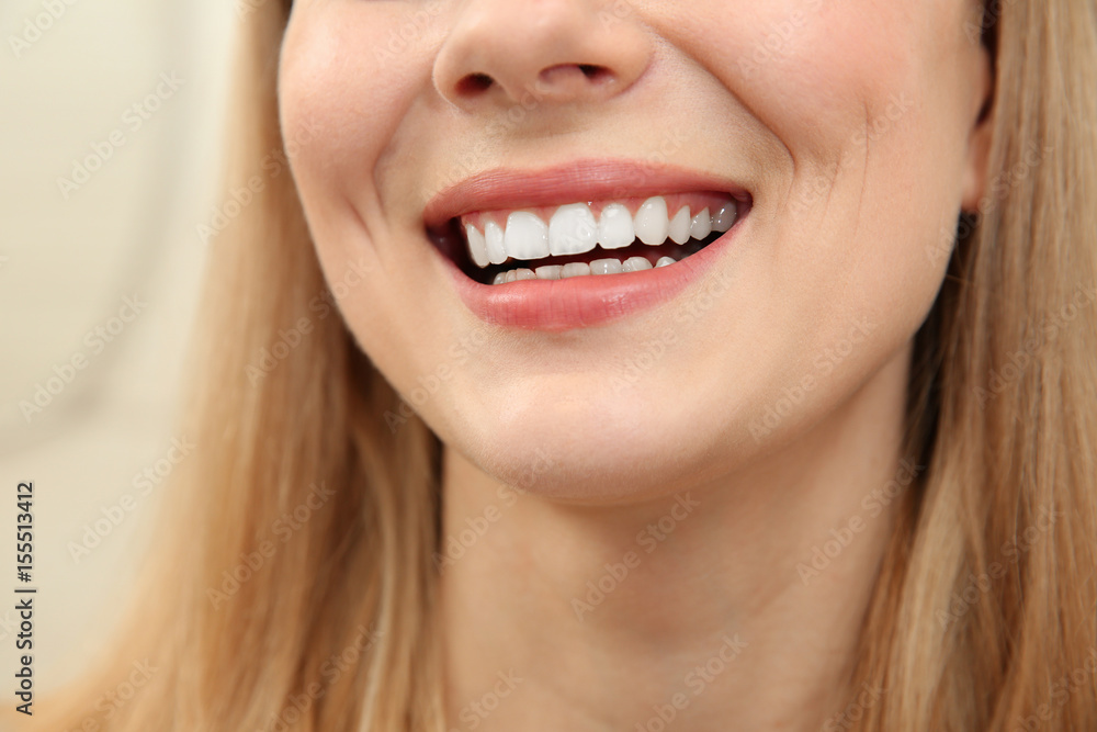 Smiling young woman on light background, close up Smiling young woman on light background, close up