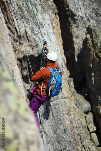 A rock climber climbs the wall in the mountains.
