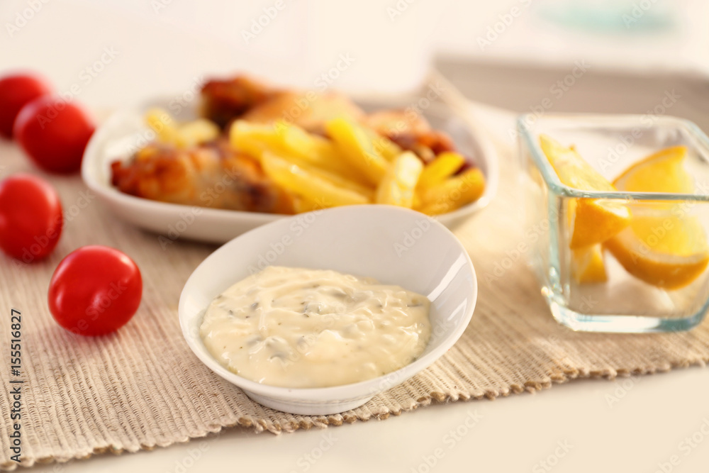Bowl with tasty mayonnaise sauce on kitchen table