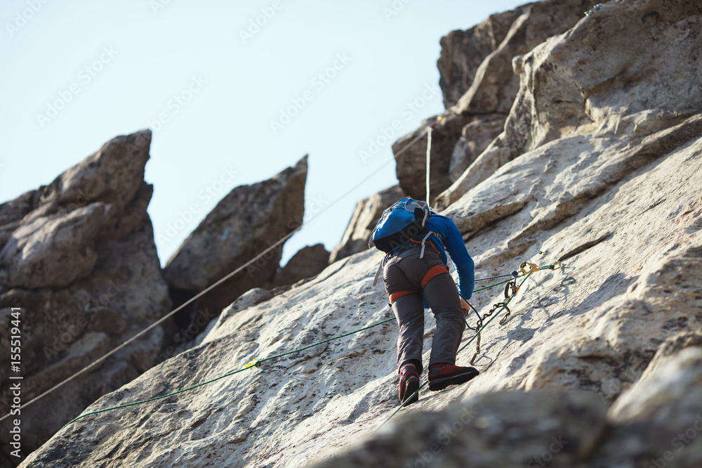 A rock climber climbs the wall in the mountains.