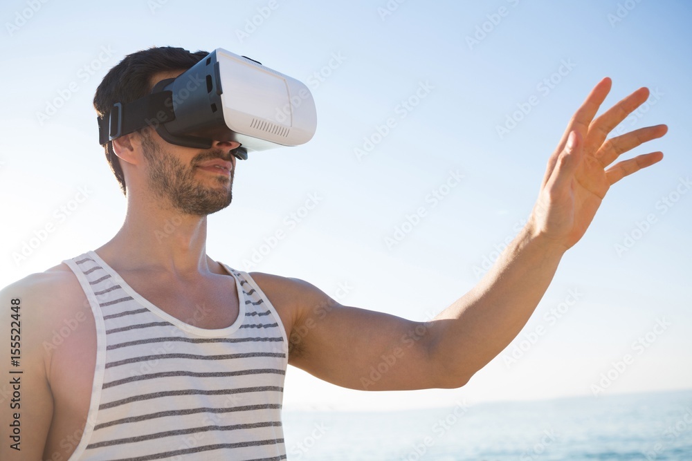 Young man using virtual reality glasses at beach Young man using virtual reality glasses at beach