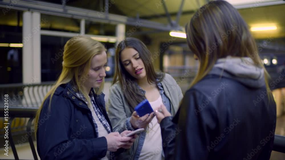 Teens Hang Out At Shopping Mall, Check Their Phones, Girls Shows Her Friends Something Funny On Her Phone, They Laugh Teens Hang Out At Shopping Mall, Check Their Phones, Girls Shows Her Friends Something Funny On Her Phone, They Laugh