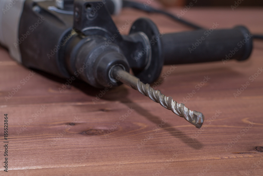 Hammer drill on a wooden background. Close-up. The electric tool Hammer drill on a wooden background. Close-up. The electric tool