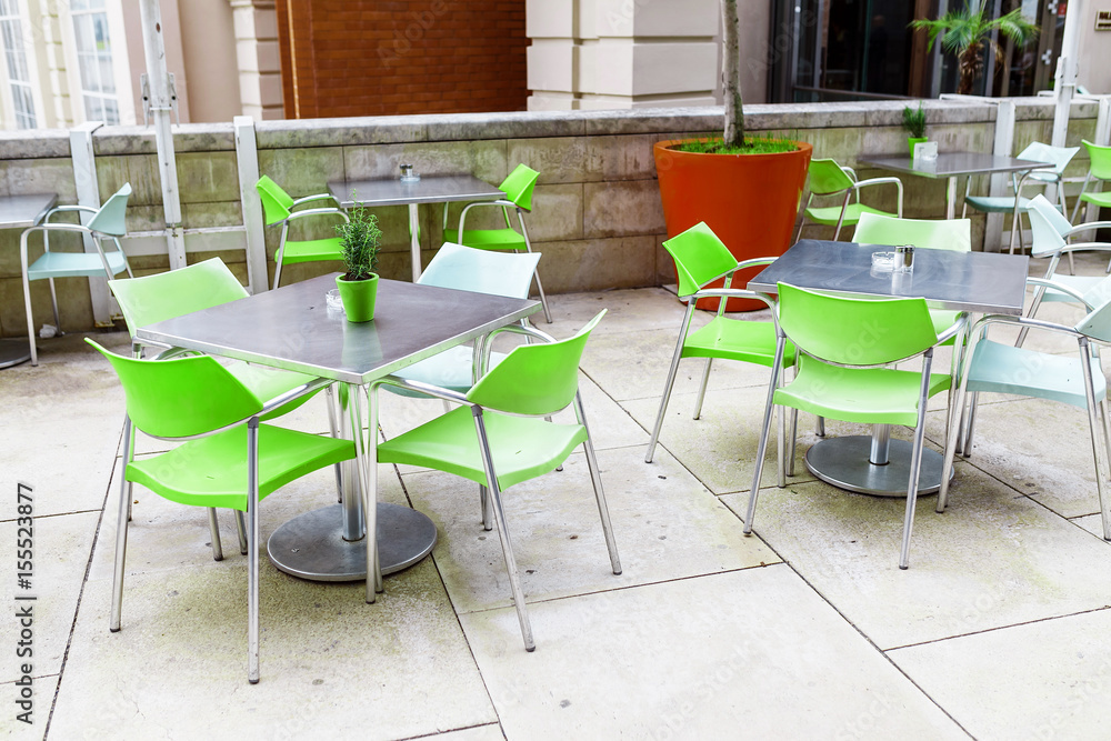 Outdoor empty cafe at city street with chairs and table