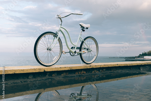 Vintage female bicycle on the background of the sea and the rainbow