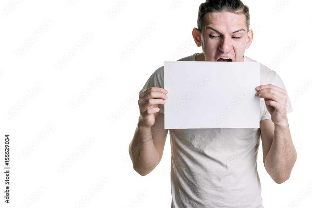 A young handsome guy with a clean sheet of paper, wants to eat a leaf. Place for signature, text. Horizontal frame A young handsome guy with a clean sheet of paper, wants to eat a leaf. Place for signature, text. Horizontal frame