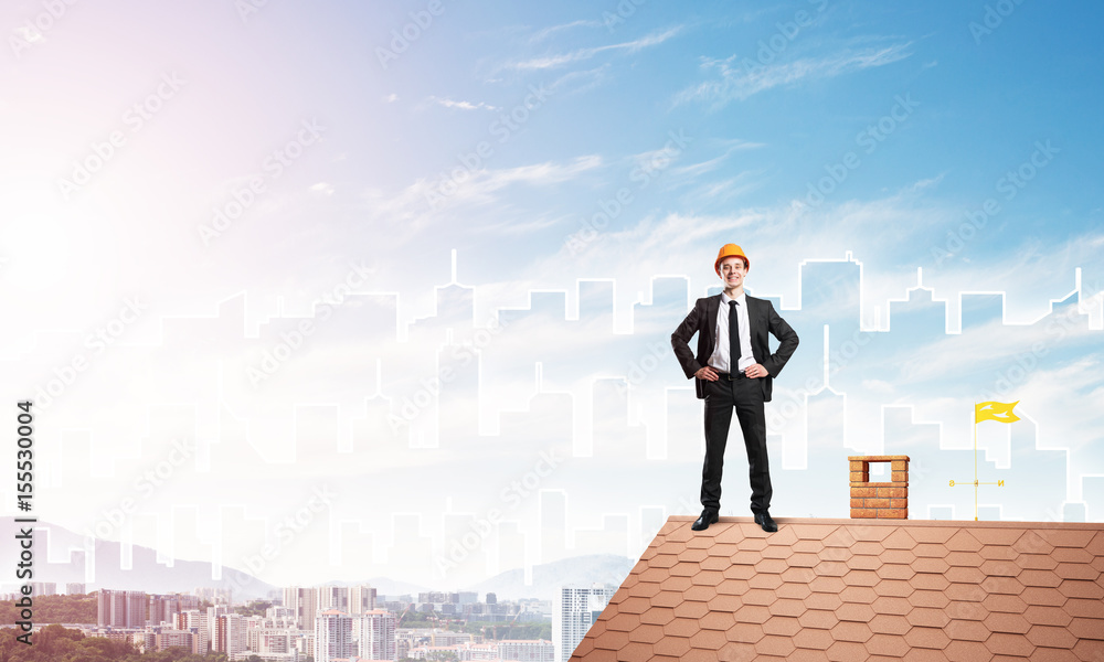 Engineer man standing on roof and looking away. Mixed media Engineer man standing on roof and looking away. Mixed media