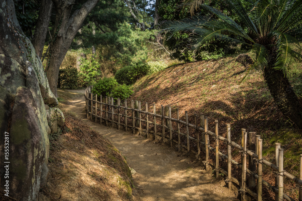 Gravel footpath in the Ritsurin Koen-Chestnut Grove Garden between bamboo fences