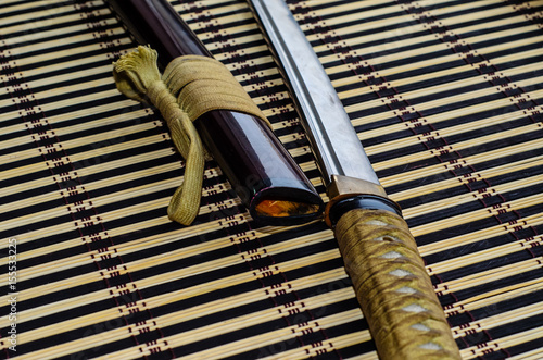 Fototapeta Naklejka Na Ścianę i Meble -  Japanese sword katana on bamboo mat