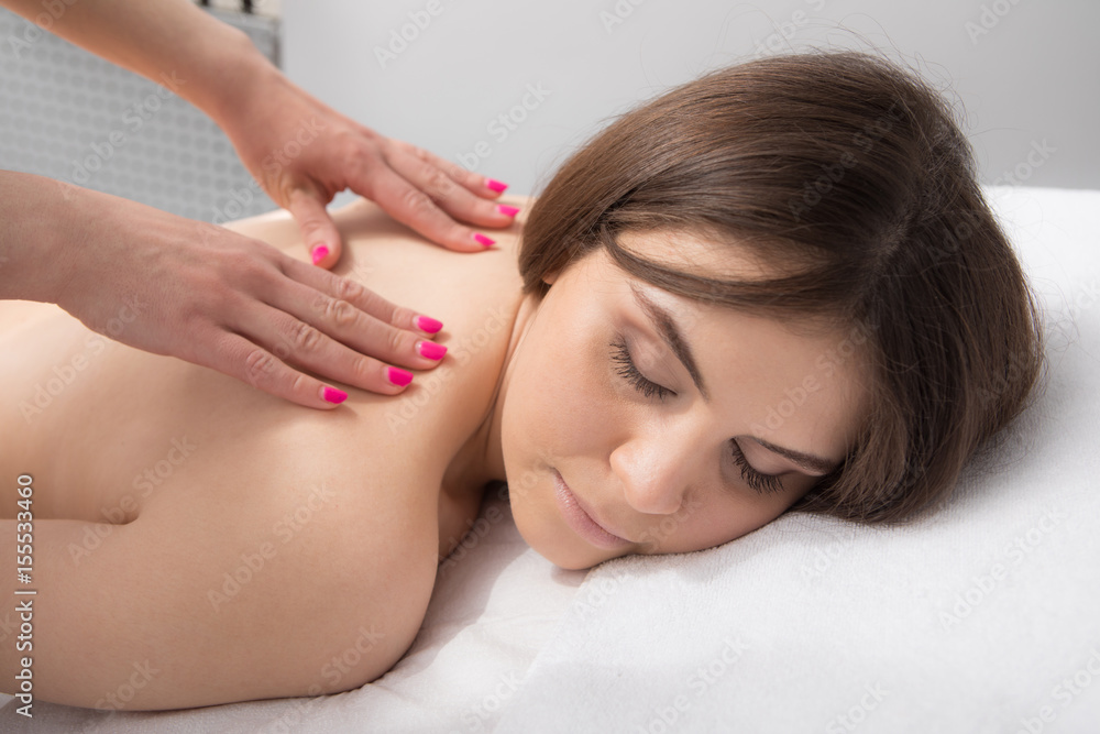 Relaxed smiling woman receiving a back massage

