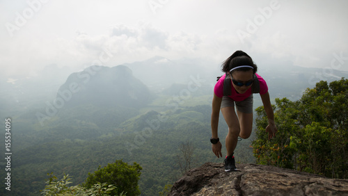 Young fitness woman trail runner running at mountain top