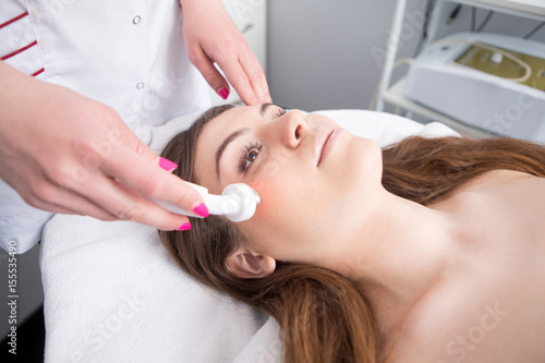 Obraz na płótnie Woman getting laser face treatment in medical spa center
w salonie