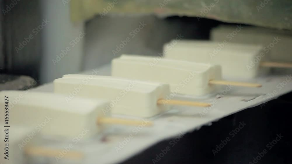 Food production line. Ice cream production line. Food factory. Close up of ice cream manufacturing line. White ice cream on conveyor belt. Food industry. Food processing plant. Ice cream manufacture Food production line. Ice cream production line. Food factory. Close up of ice cream manufacturing line. White ice cream on conveyor belt. Food industry. Food processing plant. Ice cream manufacture