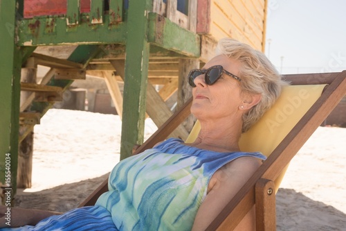 Close up of senior woman with sunglasses resting on chair photo