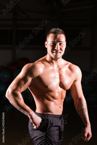 Strong Athletic Man Fitness Model Torso showing six pack abs in gym