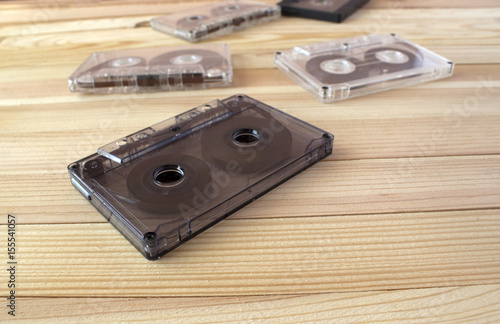 Several sound cassettes lie on a wooden background