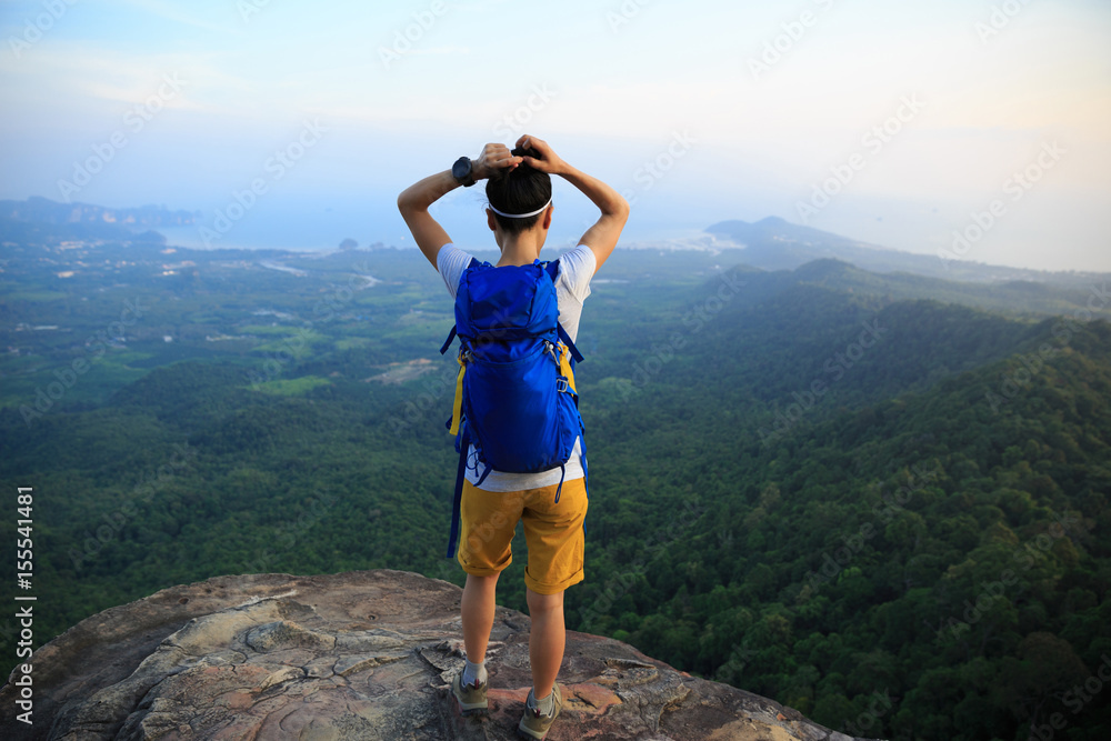 Obraz premium successful woman hiker enjoy the view hiking on mountain peak