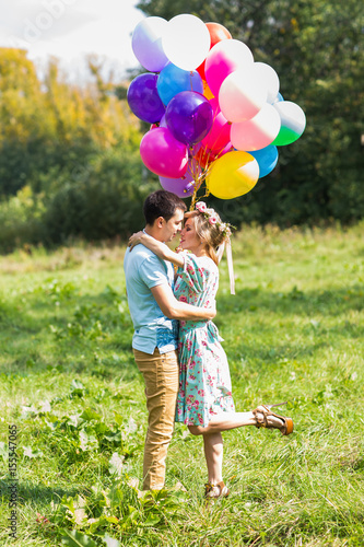 summer holidays, celebration and dating concept - couple with colorful balloons in nature