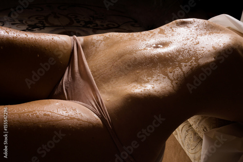 Female slim belly on a dark background.