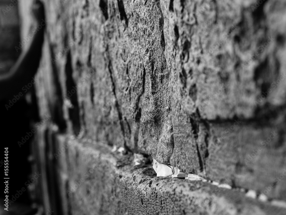 Φωτογραφία side view of huge stones of the wailing wall with a lot of prayer paper notes inserted between two stones