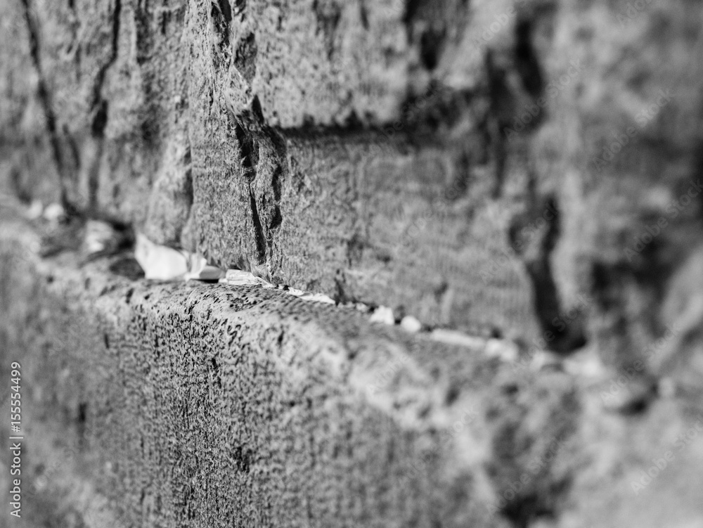 Φωτογραφία side view of huge stones of the wailing wall with a lot of prayer paper notes inserted between two stones