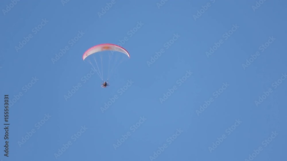 Extreme people go paragliding, flying high in blue sky, enjoying adventure sport Extreme people go paragliding, flying high in blue sky, enjoying adventure sport