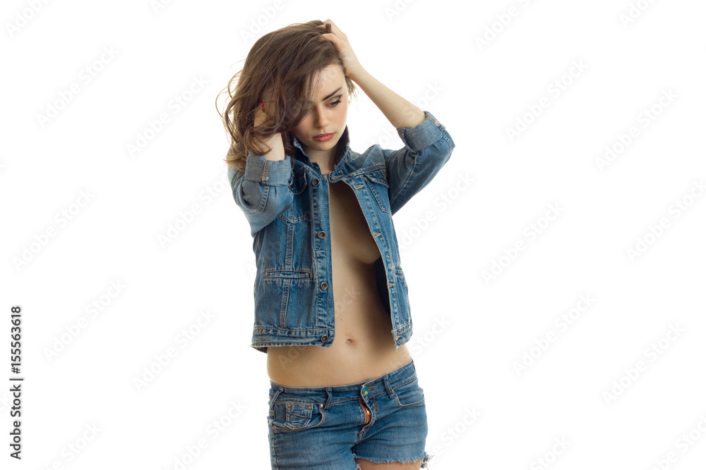 gorgeous young brunette in jeans jacket keeps your hands beautiful hair and looks toward gorgeous young brunette in jeans jacket keeps your hands beautiful hair and looks toward