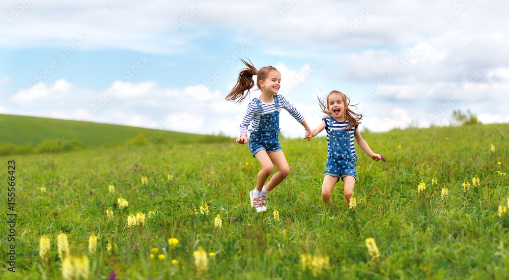 happy children twins sisters jumping and laughing in summer happy children twins sisters jumping and laughing in summer
