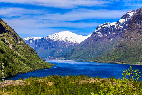 A beautiful spring day with snow on the mountain peaks, blue sky and green hills in Loen in Stryn.