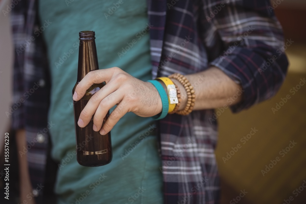 Midsection of man holding beer bottle Midsection of man holding beer bottle