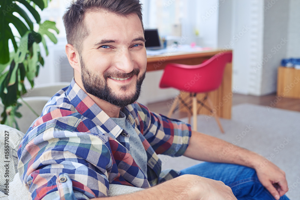 Handsome man with blue eyes relaxing on fashionable sofa Handsome man with blue eyes relaxing on fashionable sofa