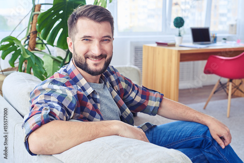 Nice mister relaxing on fashionable sofa