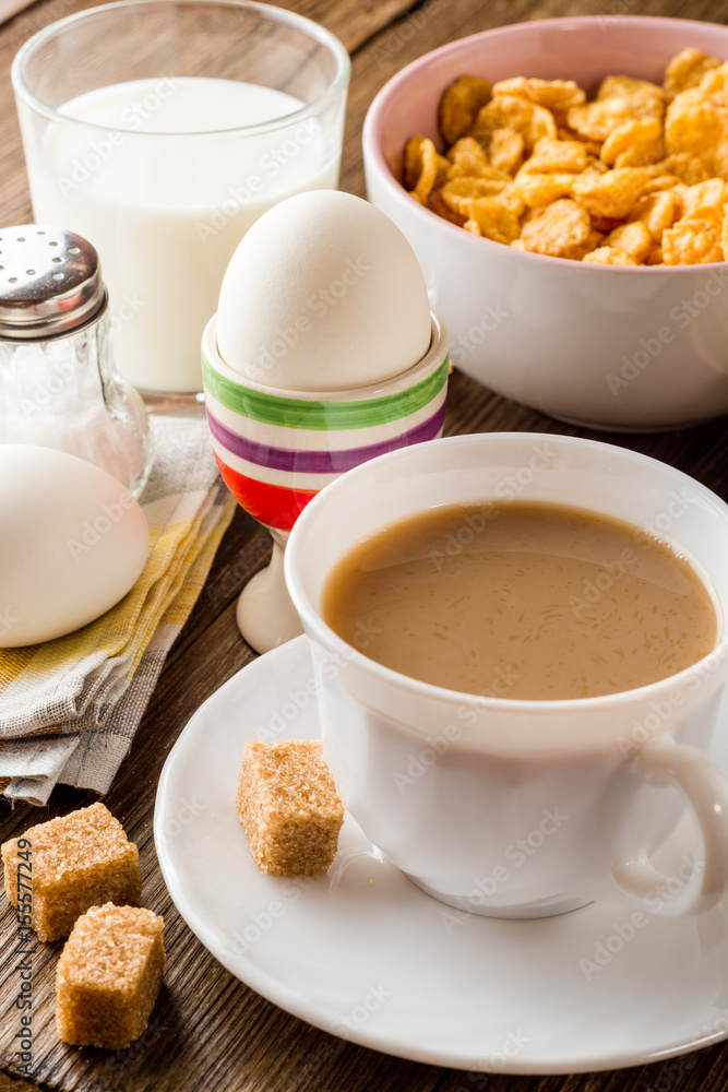 Breakfast table with coffee, boiled eggs, pancakes, cornflakes and milk. Breakfast table with coffee, boiled eggs, pancakes, cornflakes and milk.