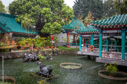 un étang dans le jardin d'un temple de chinois sous la pluie