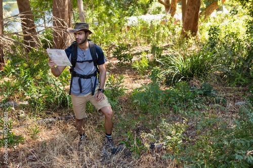 Man reading the map in the forest