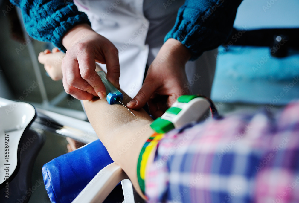 Doctor making blood analysis young girl patient. Blood sampling from a vein on the background of the clinic