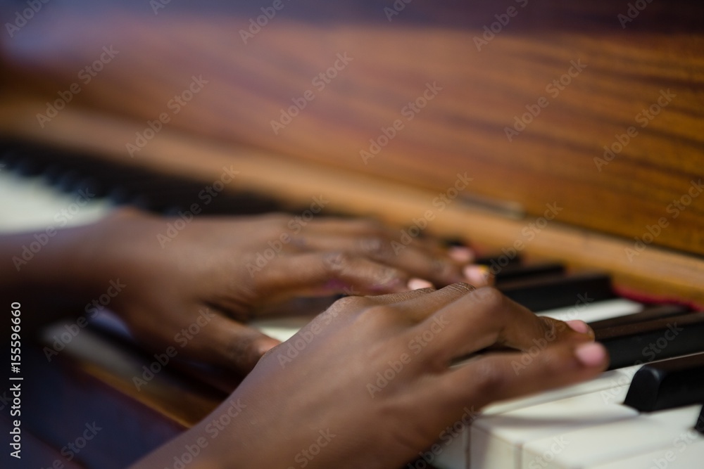 Fototapeta premium Close up of boy playing piano in classroom