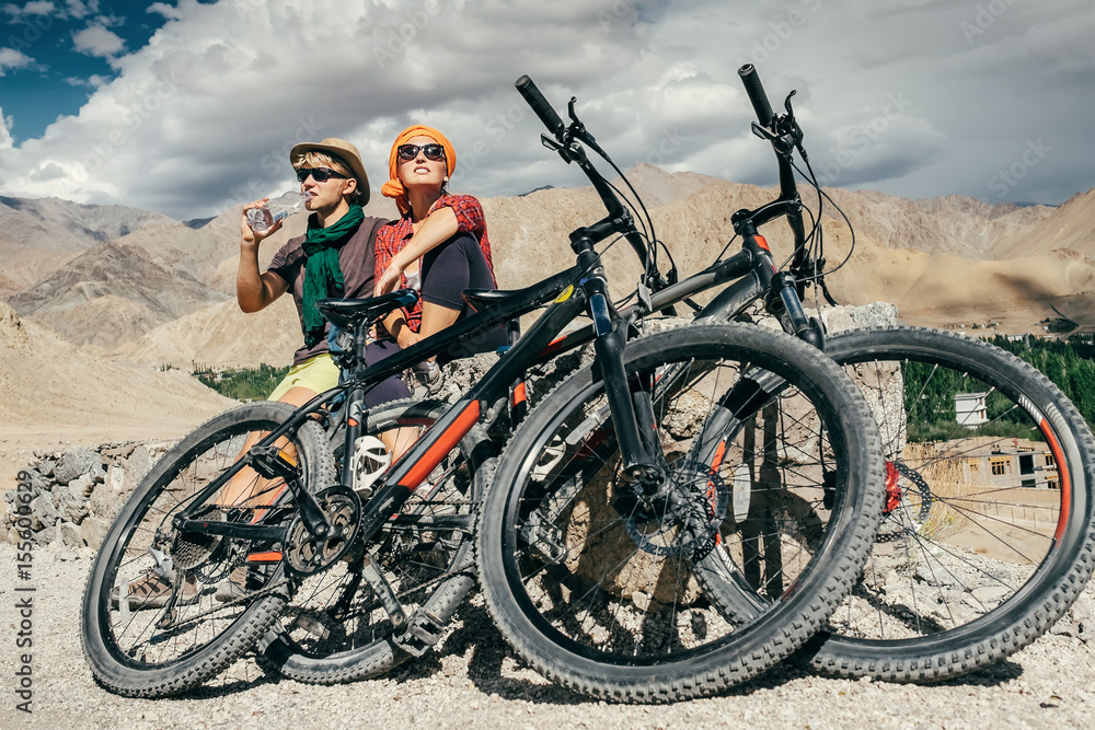 Obraz premium Two cyclists rest n the mountain road