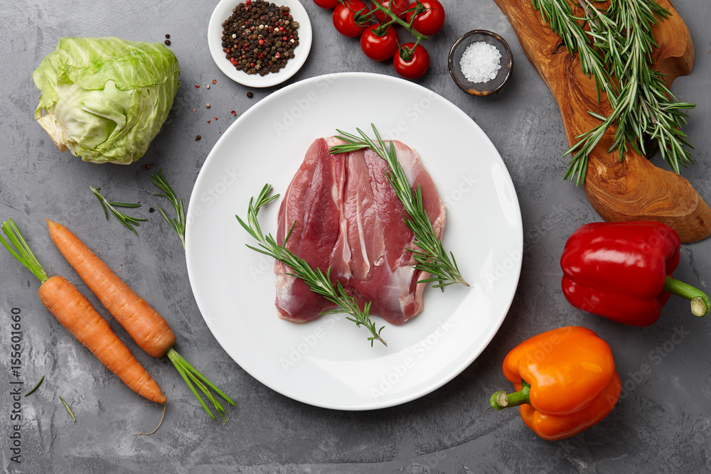 Raw duck breast, fresh vegetables, herbs and spices on gray stone background, top view