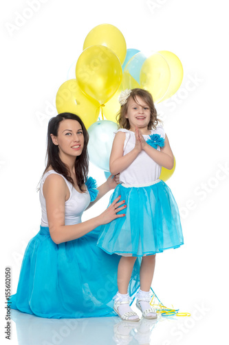 Mom and daughter with colorful balloons.