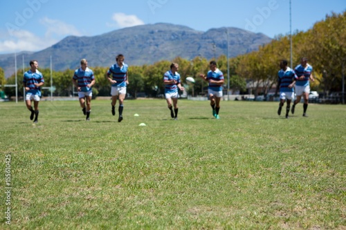 Rugby team playing match at grassy field