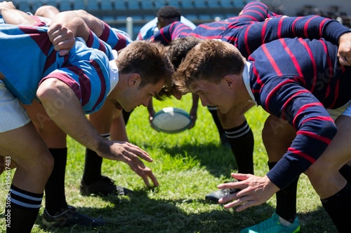 Vászonkép Close up of men playing rugby at grassy field