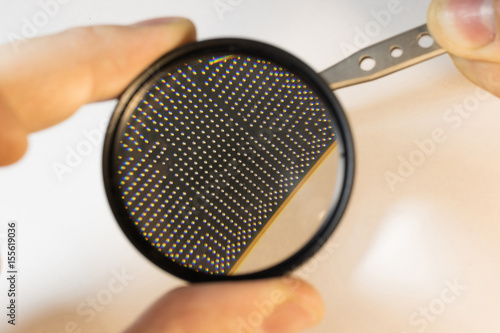 inspection the contacts of a bga chip under a magnifying glass