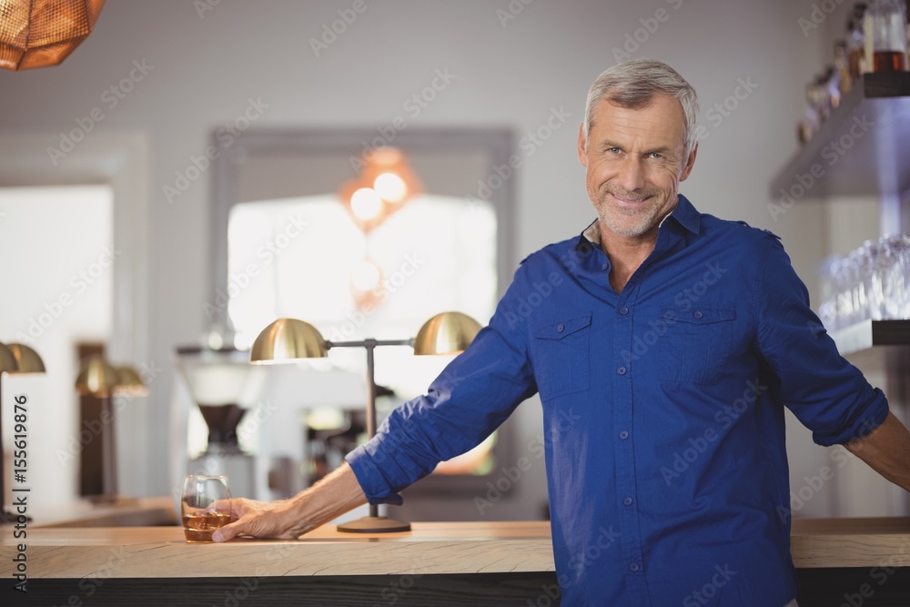 Portrait of mature man standing at counter Portrait of mature man standing at counter