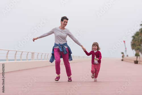 mother and cute little girl on the promenade by the sea