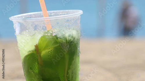Ice cold Mojito drink sitting in the sand
