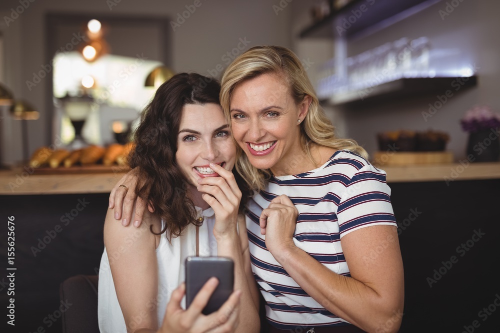 Portrait of happy friends using mobile phone Portrait of happy friends using mobile phone