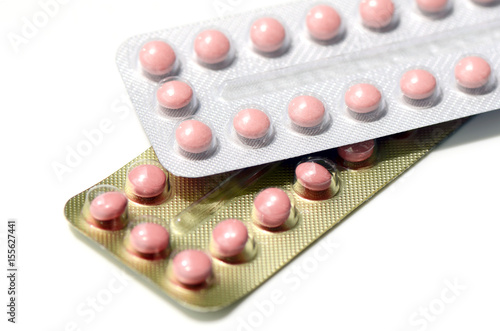 Pink pills in silver and gold strips photo