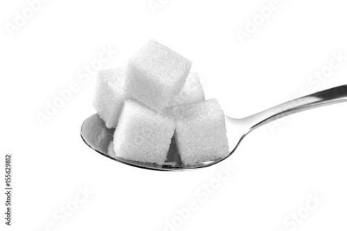 Sugar cubes in spoon on white background